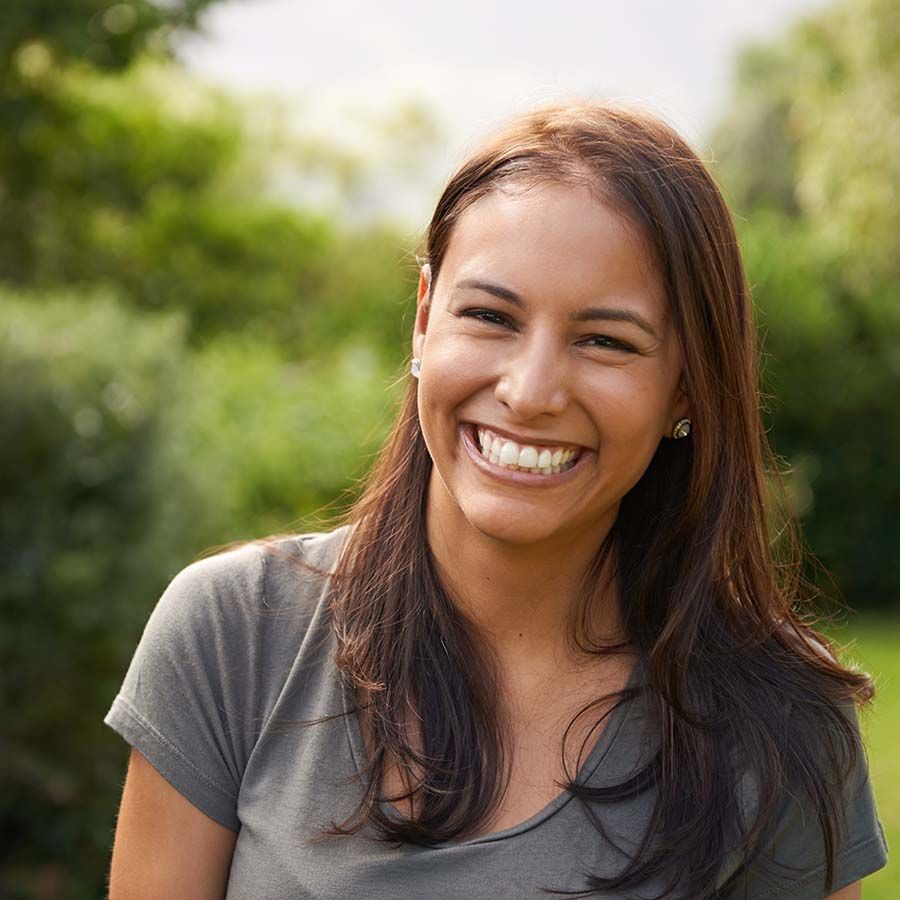 A woman smiling outdoors.