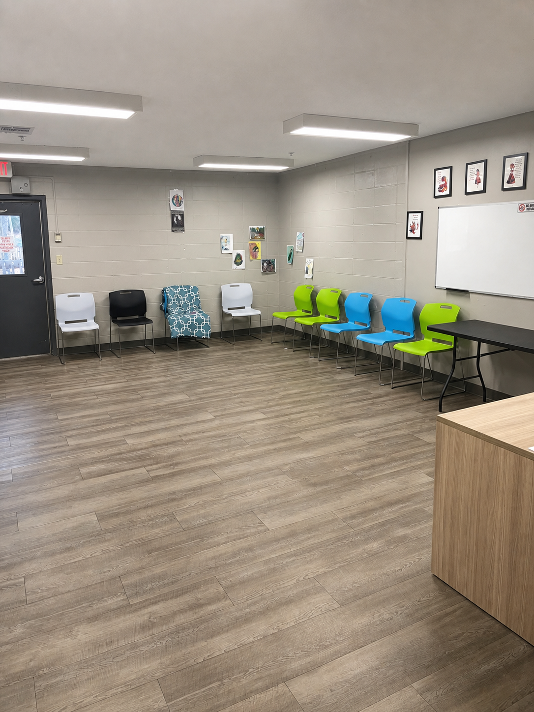 A group room at Hickory Grove Recovery in Morrilton, Arkansas — a circle of chairs facing a whiteboard, with patient artwork on the walls.