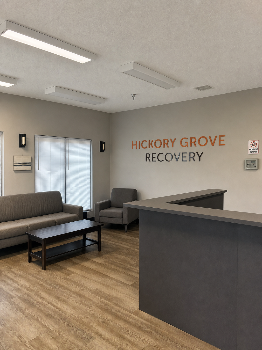 The reception lobby at Hickory Grove Recovery in Morrilton, Arkansas — the Hickory Grove Recovery wordmark on the wall above the reception desk.