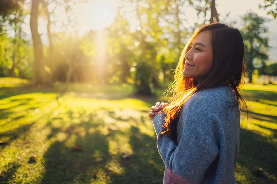 a woman at the park smiles at something out of frame