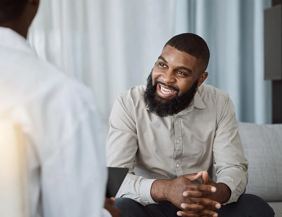 a man smiles when discussing his progress in therapy
