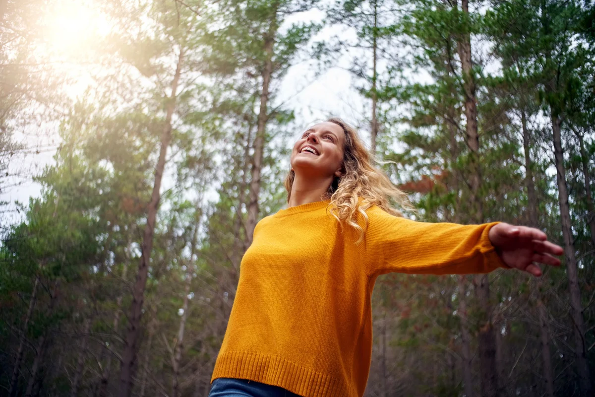 Woman looking up at trees