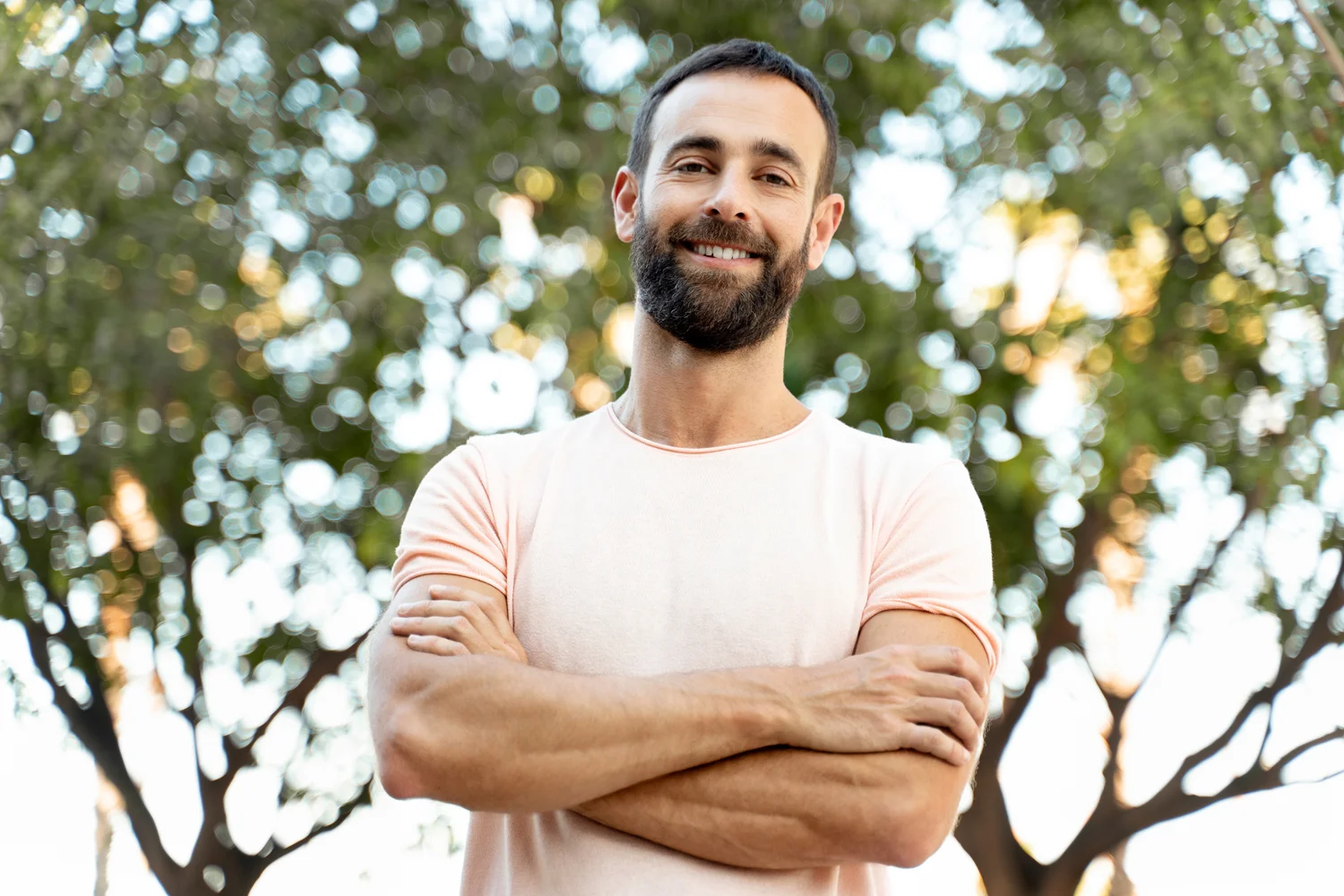 Man smiling in front of trees