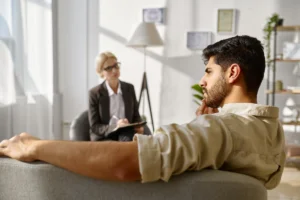 Man sitting on couch pensive at therapist's office